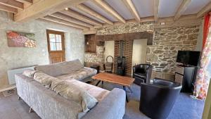 a living room with a couch and a table at Amboiras in La Croisille-sur-Briance