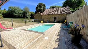 a backyard with a swimming pool and a wooden deck at Amboiras in La Croisille-sur-Briance