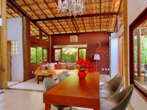 a dining room with a table and a couch at Casa Morada dos Pássaros in Imbassai