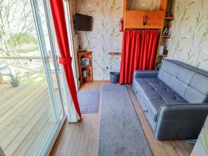 a living room with a couch and a sliding glass door at Riverside Cabin in Peterborough