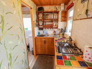 a kitchen with a stove and a counter top at Riverside Cabin in Peterborough
