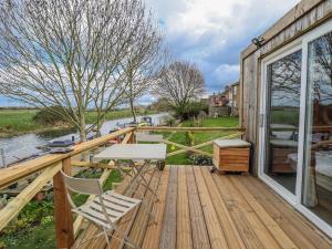 a wooden deck with a table and chairs on it at Riverside Cabin in Peterborough