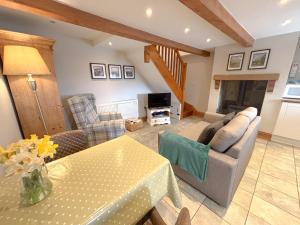 a living room with a table and a couch at School House Cottage in Buxton +17 photos