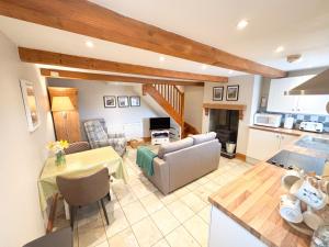 a kitchen and living room with a couch and a table at School House Cottage in Buxton
