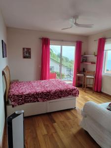 ein Schlafzimmer mit einem Bett mit roter Bettwäsche und einem Fenster in der Unterkunft Oceanview room in Ponta Delgada