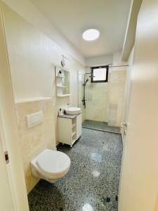 a bathroom with a toilet and a sink and a shower at B1 Apartments Deluxe in Năvodari +13 photos