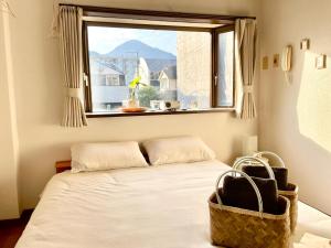 a bed in a room with a window at 眠りの癒201 I Cozy Apt, 3min Beach, Bus, Train, Onsen, Izakaya, WiFi in Beppu
