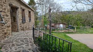 a fence next to a building with a cow in a yard at O Viraventos in Betanzos