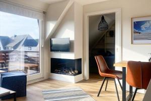 a living room with a fireplace and a window at Ferienwohnung-Sturmfri-e-se in Hörnum