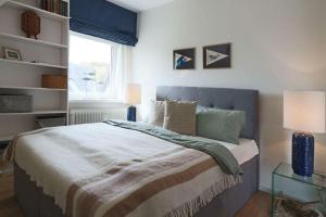 a bedroom with a large bed and a window at Ferienwohnung-Sturmfri-e-se in Hörnum +16 photos