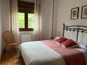 a bedroom with a bed and a chair and a window at El Descanso del Cares in Arenas de Cabrales +16 photos
