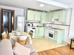 a kitchen with green cabinets and a table and a kitchen with a tableablish at El Descanso del Cares in Arenas de Cabrales