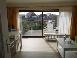 a living room with a large sliding glass door at RUeM-HART-I-Whg-2 in Hörnum