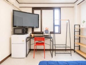 a room with a desk with a tv and a red chair at 더스테이365 스탠다드 in Seoul