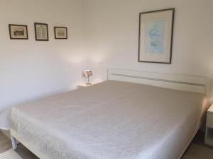 a bedroom with a white bed and a lamp on a table at RUeM-HART-I-Whg-2 in Hörnum