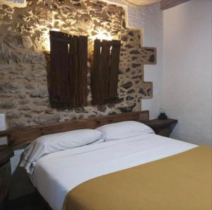 a bed in a room with a stone wall at O Viraventos in Betanzos