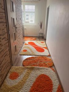 a hallway with orange and white rugs on the floor at Apartman Pod Vysokymi Tatrami in Nová Lesná +3 photos