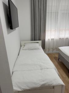 a bedroom with a bed with a tv on the wall at Apartmani Novak in Mostar +17 photos