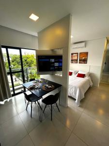 a bedroom with a bed and a table and chairs at RCM Vilas - Apartamento 306 in Joinville