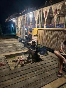 a group of people sitting on a deck at night at Sleep tourism Maewang in Ban Huai Rin +8 photos