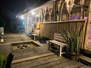 a wooden deck with a bench and a fire pit at Sleep tourism Maewang in Ban Huai Rin