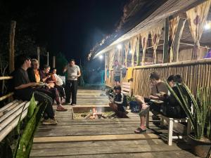 a group of people sitting around a fire at night at Sleep tourism Maewang in Ban Huai Rin
