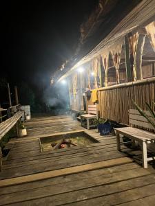 a wooden deck with benches and a building at night at Sleep tourism Maewang in Ban Huai Rin