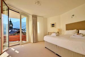 a bedroom with a bed and a large window at Eiger Residence 2 in Wengen +25 photos