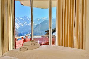 a bedroom with a bed with a view of mountains at Eiger Residence 2 in Wengen