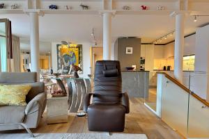 a living room with a chair and a kitchen at Eiger Residence 2 in Wengen