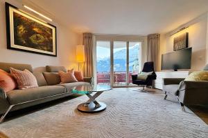 a living room with a couch and a table at Eiger Residence 2 in Wengen