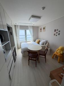 a bedroom with a bed and a table in a room at 여유스테이 in Suwŏn-yŏk