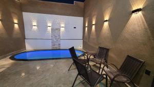 a swimming pool in a room with chairs and tables at Casa Tecnoshow 2026 in Rio Verde