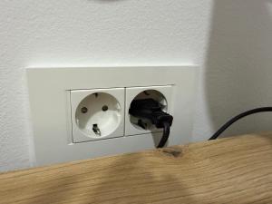 a phone is plugged into a lightswitch in a wall at Apartmani Novak in Mostar