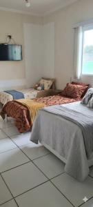 a bedroom with two beds and a tv on the wall at Chácara Recanto do Sossego in Araçoiaba da Serra +4 photos