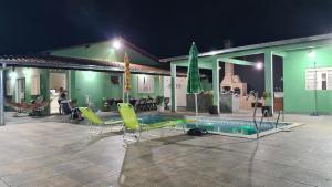 a house with a swimming pool and some chairs at Chácara Recanto do Sossego in Araçoiaba da Serra