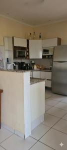 a kitchen with white cabinets and a stainless steel refrigerator at Chácara Recanto do Sossego in Araçoiaba da Serra