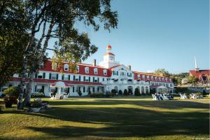 ein großes rot-weißes Gebäude mit einem Uhrturm in der Unterkunft Hotel Tadoussac in Tadoussac