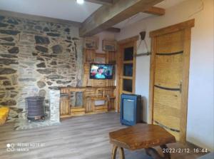 a living room with a stone wall and a tv at O Viraventos in Betanzos