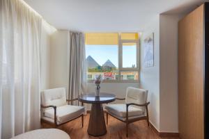 a room with a table and two chairs and a window at Superior Pyramids View in Cairo
