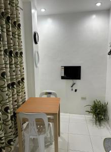 a dining room table with two chairs and a tv on a wall at Private Room at MA Compound in Concepcion +6 photos