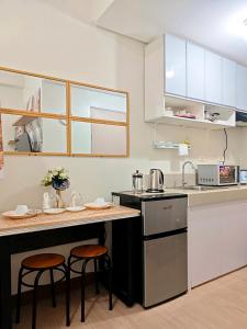 a kitchen with two bar stools and a counter top at R&N Trees Residence in Manila