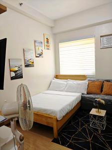 a bedroom with a bed and a chair and a window at R&N Trees Residence in Manila +29 photos