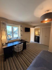 a hotel room with a desk and a window at The Red Lion Bed and Breakfast in Kings Walden