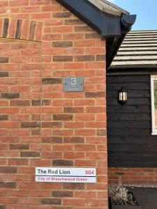 a red brick building with a red lion sign on it at The Red Lion Bed and Breakfast in Kings Walden