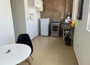 a small kitchen with a table and a refrigerator at STUDiOS RAYON in Morelia +7 photos