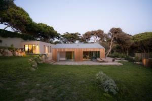 a house with a metal roof on top of a yard at Guincho Lodge in Alcabideche