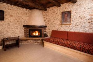 a living room with a couch and a fireplace at Vertigo Stone Villa - Roumeli Private Pool Escape in Roumelí