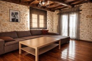a living room with a couch and a coffee table at Vertigo Stone Villa - Roumeli Private Pool Escape in Roumelí