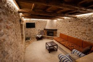 a living room with a couch and a fireplace at Vertigo Stone Villa - Roumeli Private Pool Escape in Roumelí
